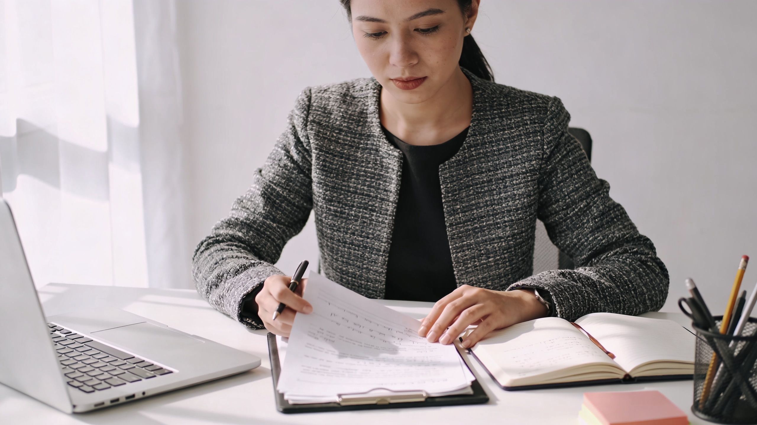 Une femme d'affaires concentrée travaille sur des documents importants lors de son entretien annuel individuel au bureau.
